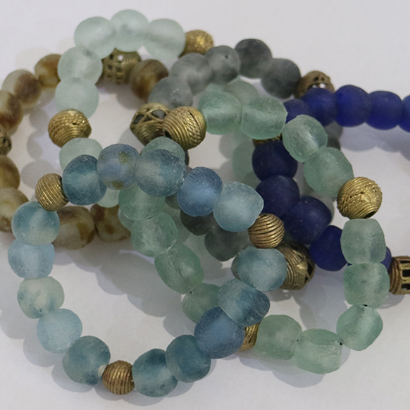 Colorful beaded bracelets with gold accents on a white background.