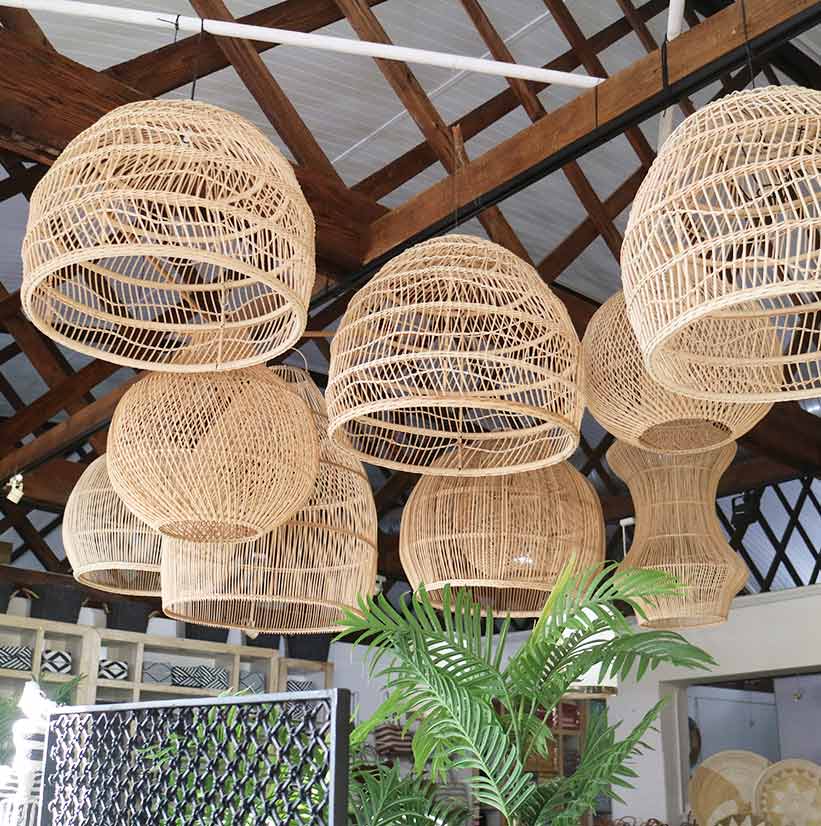 Hanging wicker lampshades in a rustic interior setting with wooden beams.